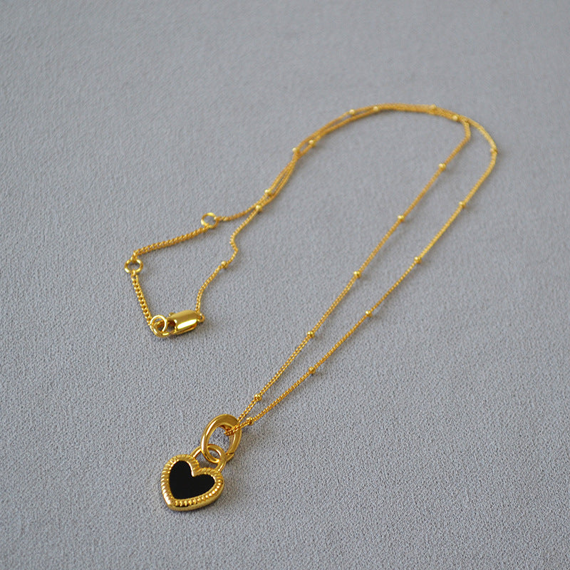 Collier dorée avec pendentif en forme de cœur noir et blanc