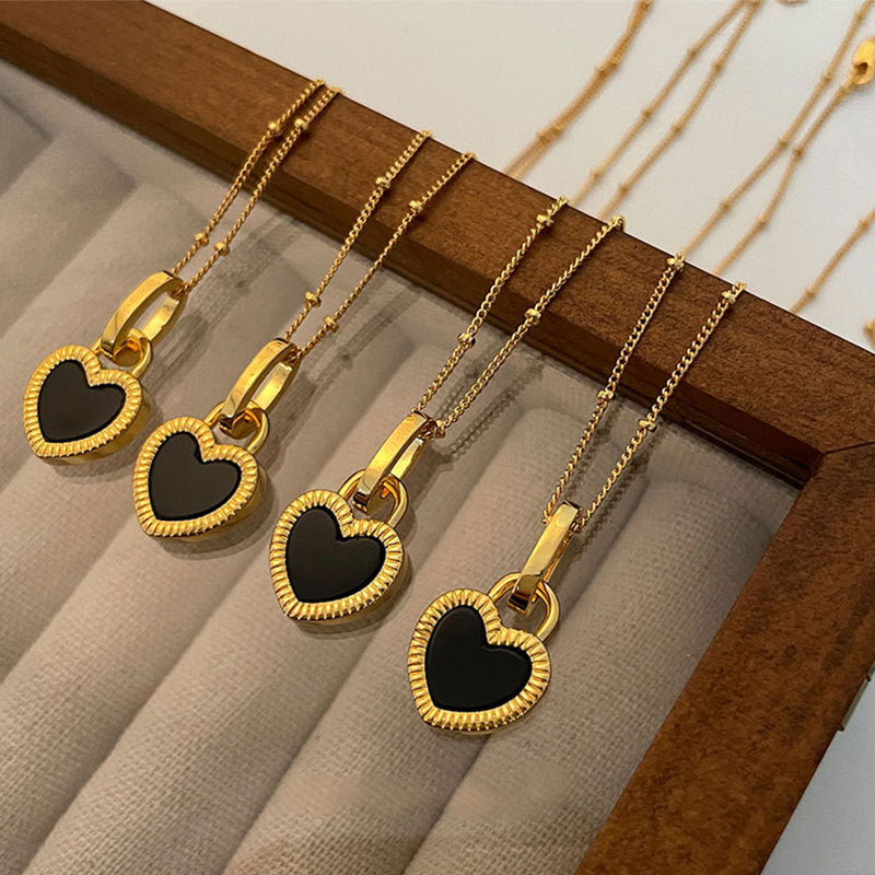 Collier dorée avec pendentif en forme de cœur noir et blanc